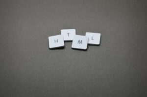 Minimalist image of HTML keycaps against a gray background, perfect for digital and web design themes.